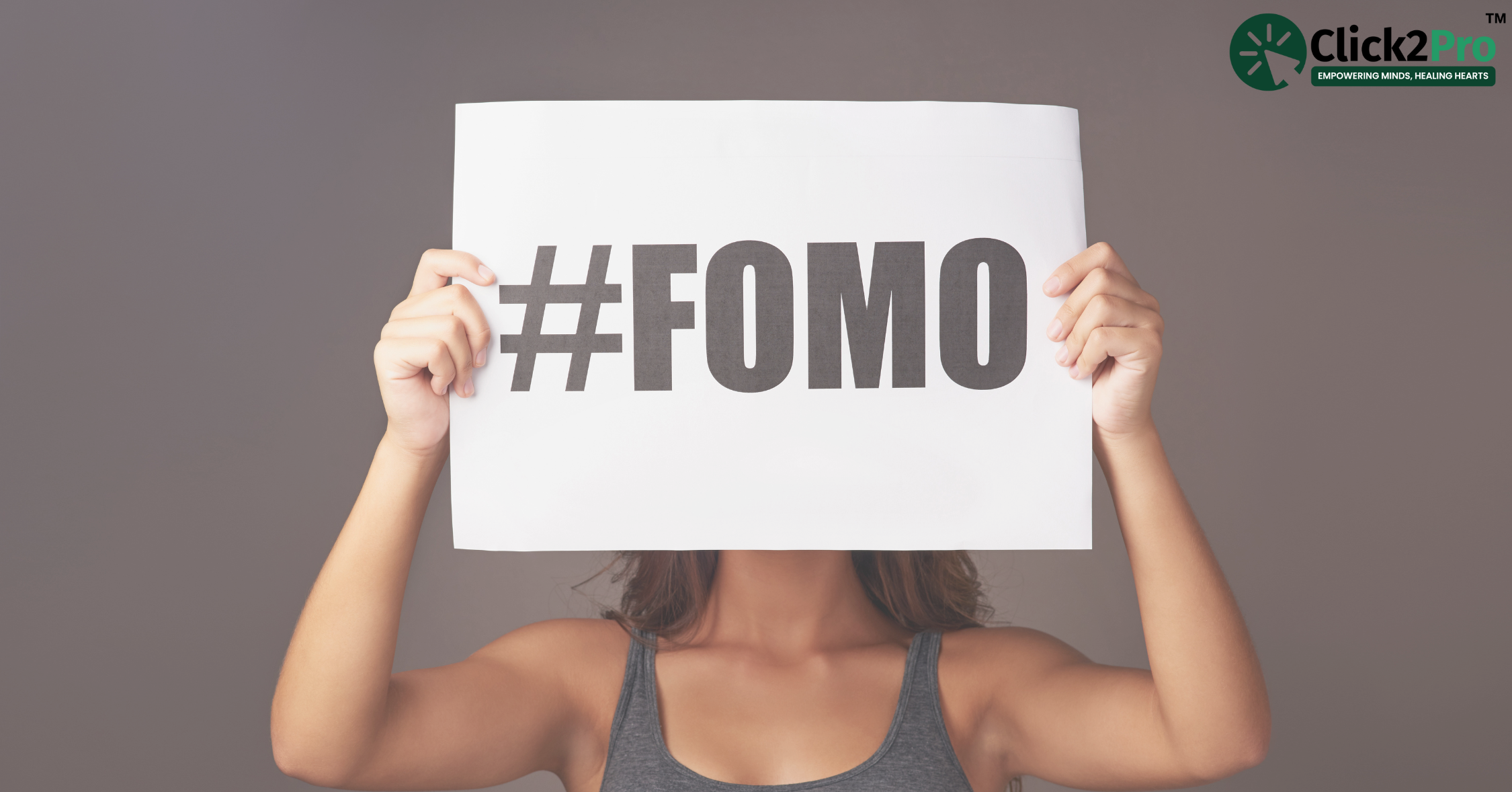 Teen holding #FOMO sign, highlighting fear of missing out in teenagers. Click2Pro mental health support.