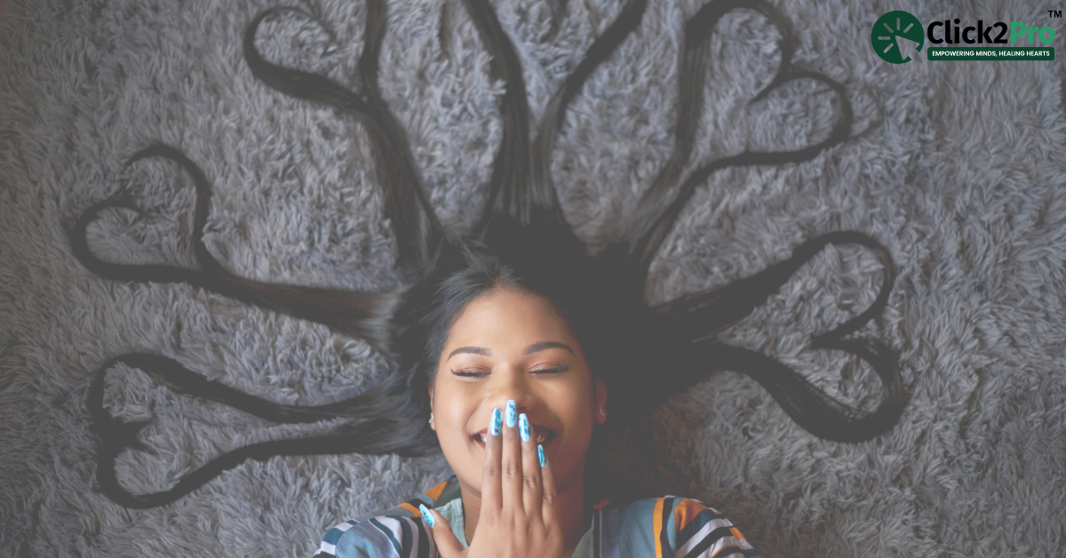 Smiling woman with hair forming heart shapes, symbolizing self-care and mental health support for caregivers.