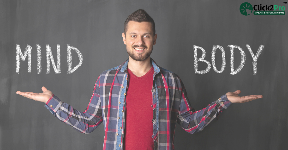 Man holding 'Mind' and 'Body' text, symbolizing the connection between emotional trauma and physical health.