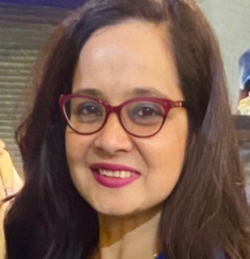 Female psychologist with glasses and a warm smile providing therapy at Click2Pro